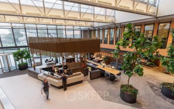 Moderne lobby in kantoorpand op Jachthavenweg 109, Amsterdam Zuidas, met grote planten en ontvangstruimte. Ideaal voor kantoorruimte huren.