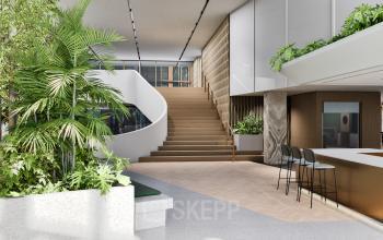 Moderne entree bij kantoorpand aan de Claude Debussylaan 80-134, Amsterdam Zuidas, met veel groen en stijlvolle trap, ideaal voor bedrijven om kantoorruimte te huren.