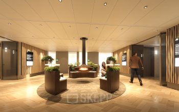 Moderne lobby in het kantoorpand op Claude Debussylaan 80-134, Amsterdam Zuidas, met stijlvolle zitplaatsen en een centraal geplaatste open haard. Het is een uitnodigende ruimte met warme verlichting.