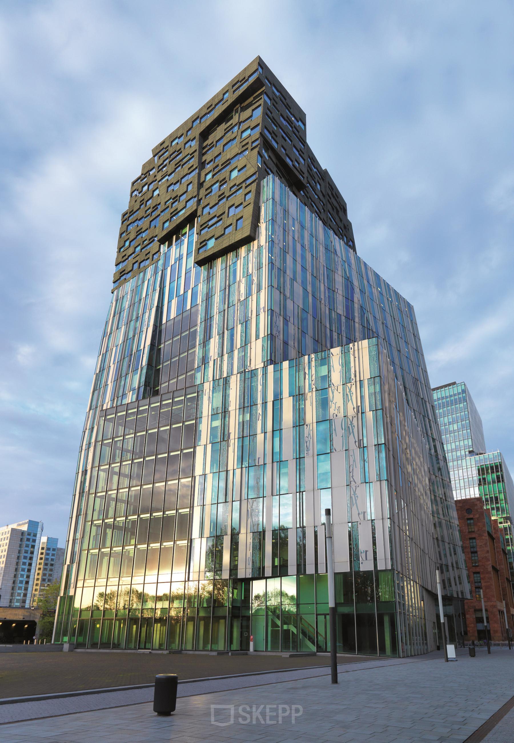 Moderne kantoorpand op de Claude Debussylaan in Amsterdam Zuidas, ideaal voor kantoorruimte huren. Het gebouw heeft een opvallende glaspui en bevindt zich in een levendige zakenwijk.