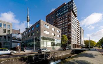 Kantoorpand aan De Boelelaan 28 in Amsterdam Zuidas met moderne architectuur en meerdere verdiepingen, gelegen aan een rustige weg met geparkeerde auto's.