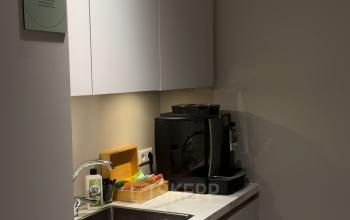 Compacte pantry met een koffiezetapparaat en spoelbak in een kantoorpand aan De Boelelaan 28, Amsterdam Zuidas. Ideaal voor een snelle koffiepauze tijdens het kantoorruimte huren.