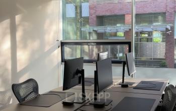 Kantoorruimte huren op De Boelelaan 28 in Amsterdam Zuidas, met moderne bureaus en stoelen, en een groot raam dat daglicht binnenlaat.