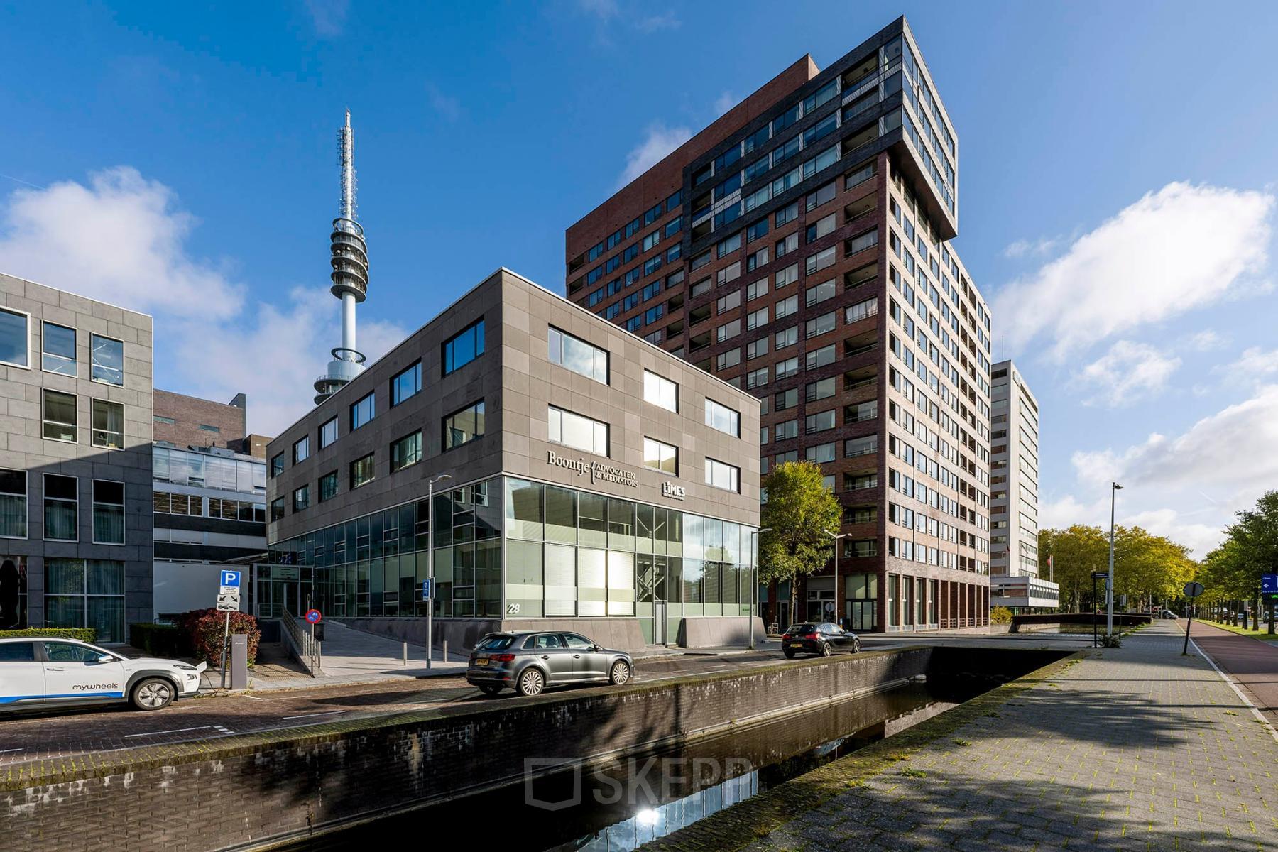 Kantoorpand aan De Boelelaan 28 in Amsterdam Zuidas met moderne architectuur en meerdere verdiepingen, gelegen aan een rustige weg met geparkeerde auto's.