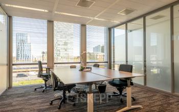 Kantoor aan Claude Debussylaan 10, Amsterdam Zuidas met ruime werkplekken, grote ramen en uitzicht op moderne gebouwen.