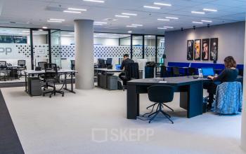 Ruime kantoorruimte met moderne inrichting op Gustav Mahlerplein in Amsterdam Zuidas, voorzien van werkplekken waar mensen aan het werk zijn.