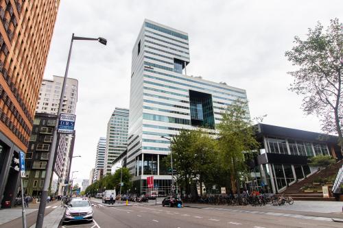 Kantoorpand aan het Gustav Mahlerplein 28 & 58-60 in Amsterdam Zuidas, omringd door andere moderne kantoorgebouwen met bomen langs de weg.