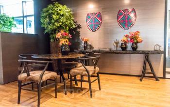 Gemeubileerde kantoorruimte aan de Claude Debussylaan 7-29 in Amsterdam Zuidas, met houten tafel en stoelen en kleurrijke decoratie aan de muur.