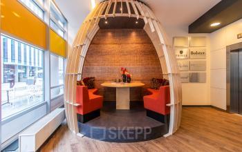 Moderne en uitnodigende kantoorruimte huren op Claude Debussylaan 7-29 in Amsterdam Zuidas met ronde zithoek en opvallende houten structuur.