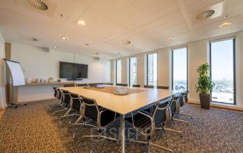 Moderne vergaderruimte huren bij Gustav Mahlerplein 109-115 in Amsterdam Zuidas, voorzien van grote ramen en voldoende zitplaatsen.