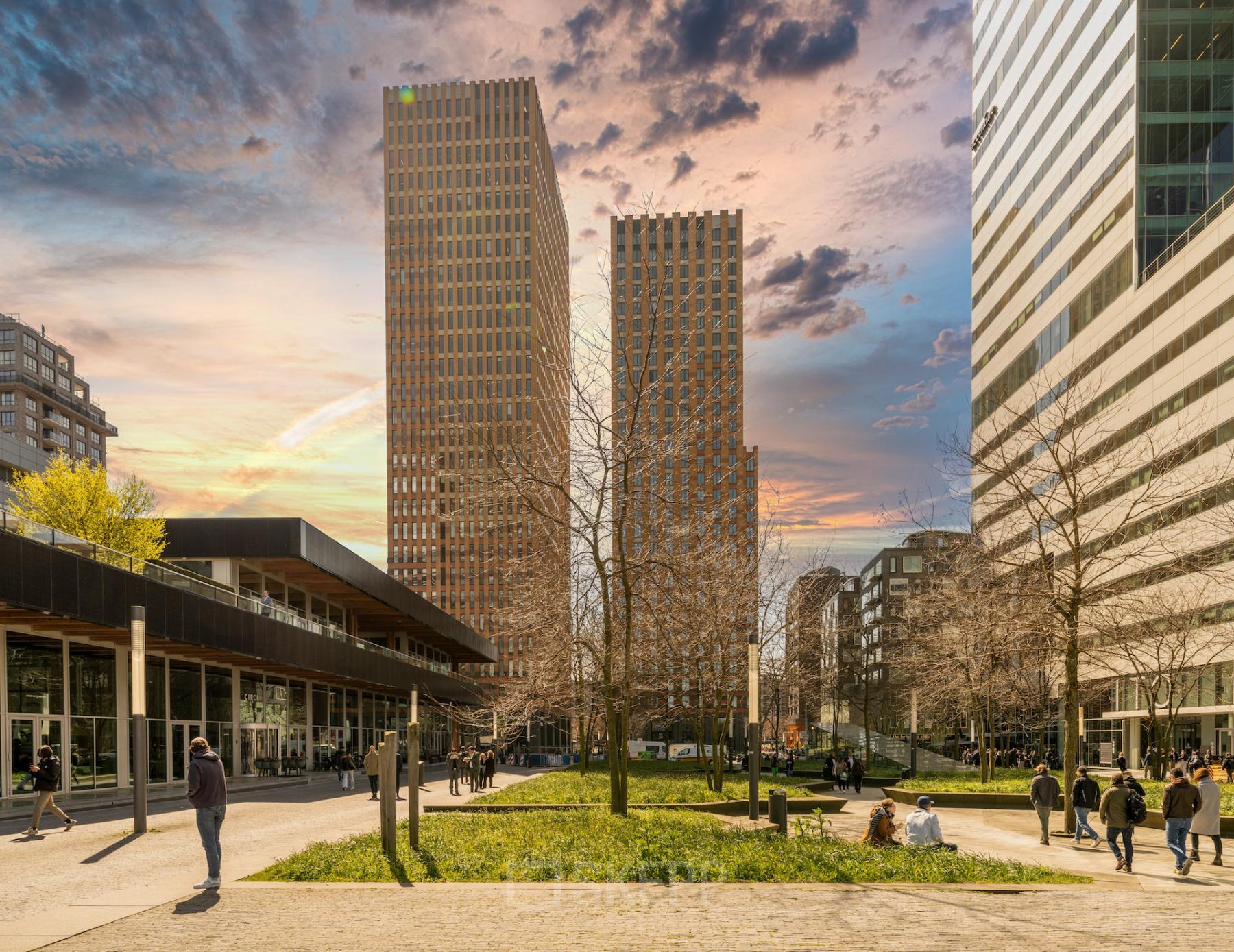 Kantoorpanden aan Gustav Mahlerplein 109-115 in Amsterdam Zuidas, bij zonsondergang, mensen lopen rond en genieten van het parkachtig gebied.