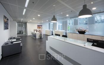 receptiebalie loungestoelen lunchtafel kantoorpand wtc amsterdam zuidas lampen ramen uitzicht