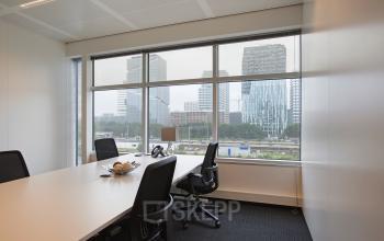kantoorruimte amsterdam zuidas tafel bureau stoelen vloerbedekking ramen uitzicht strawinskylaan