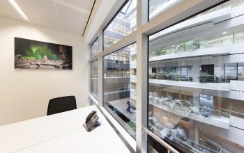 bureau bureaustoel schilderij raam uitzicht lichtinval telefoon
