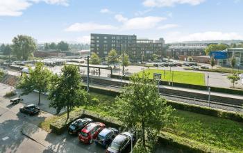 Exterieur van kantoorpand gelegen op Linie 580-596 in Apeldoorn met zicht op parkeerplaatsen en omgeving.