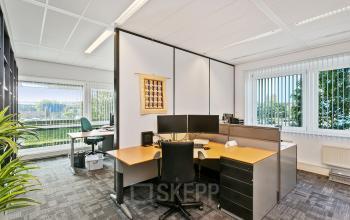 Lichte kantoorruimte met grote ramen en moderne werkplekken, gelegen op Linie 580-596, Apeldoorn. Deze ruimte biedt veel natuurlijk licht en uitzicht op groen.