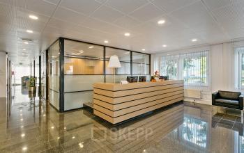 Receptie van kantoorpand Linie 580-596 in Apeldoorn met ontvangstbalie, glazen wanden en wachtstoelen.