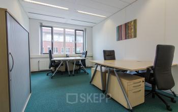 Modern ingerichte kantoorruimte te huur op Het Rietveld 55A in Apeldoorn met bureaus, stoelen en kunst aan de muur.