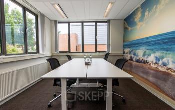 Moderne kantoorruimte in Apeldoorn aan Het Rietveld 55A met grote tafel, comfortabele stoelen en inspirerend muurkunstwerk.
