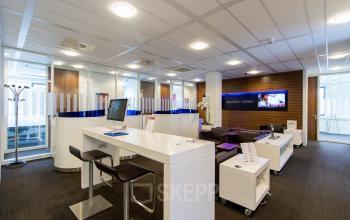 Moderne ontvangstbalie in het kantoorpand op Het Rietveld 55A in Apeldoorn, met comfortabel zitgedeelte en zakelijke uitstraling.