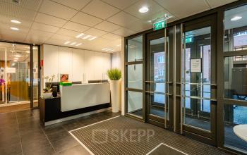 Kantoorpand op Het Rietveld 55-59, Apeldoorn, met een moderne entree en receptieruimte. De glazen deuren bieden toegang tot de kantoorruimte. Ideaal voor wie een kantoor wil huren.