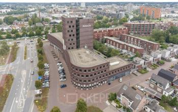 Uitzicht op het kantoorpand aan de Wapenrustlaan 11-31 in Apeldoorn, omringd door stedelijke omgeving, ideaal om kantoorruimte te huren.