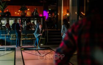 Kantoorruimte in Apeldoorn bij Wapenrustlaan 11-31, waar mensen zakelijke activiteiten ondernemen, waaronder een persoon die ontspannen bezig is met een spelelement in een informele omgeving.