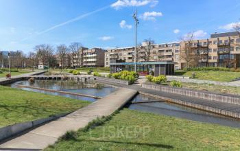 Uitzicht op het exterieur van kantoorpand Prins Willem-Alexanderlaan 301 in Apeldoorn, omgeven door groen en een vijver. Ideaal voor kantoorruimte huren met een rustige omgeving.