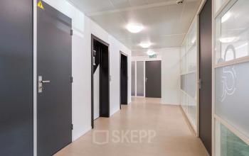 Gang in kantoorpand op Prins Willem-Alexanderlaan 301 in Apeldoorn met meerdere deuren en glazen wanden.