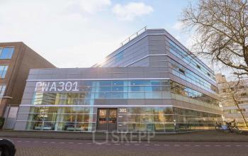 Modern kantoorpand op Prins Willem-Alexanderlaan 301 in Apeldoorn, met glazen gevel en ruime parkeerplaats vooraan. Ideaal als representatieve kantoorruimte voor bedrijven die willen huren.