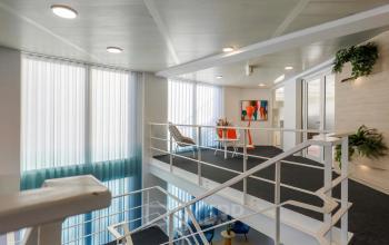 Moderne kantoorruimte te huur op de eerste verdieping van Prins Willem-Alexanderlaan 301 in Apeldoorn met strakke witte wanden en kunst aan de muur.