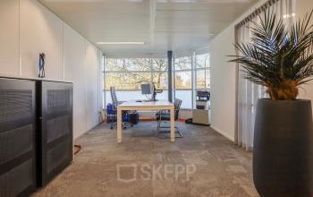 Lichte kantoorruimte in Apeldoorn met een werkplek en uitzicht op de omgeving, geschikt voor kantoorruimte huren.