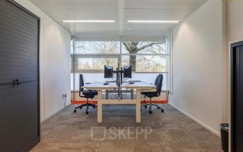 Kantoorruimte huren op Prins Willem-Alexanderlaan 301 in Apeldoorn met twee werkplekken, bureaus en stoelen, en veel natuurlijk licht.