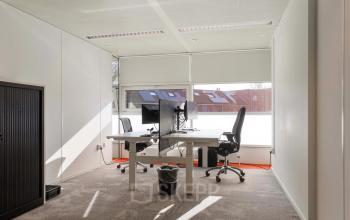 Kantoorruimte huren op Prins Willem-Alexanderlaan 301 in Apeldoorn, met twee bureaus, stoelen en computerschermen. Grote ramen bieden veel daglicht in het kantoorpand.
