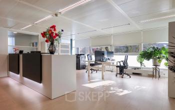 Lichte en moderne kantoorruimte huren op Prins Willem-Alexanderlaan 301 in Apeldoorn, met strakke meubels, grote ramen, bureaus en stoelen.