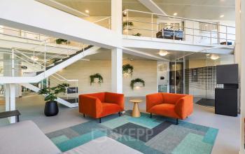 Moderne kantoorruimte te huur aan de Prins Willem-Alexanderlaan 301 in Apeldoorn, met kleurrijke meubels en een open indeling. Het kantoorpand is ingericht met zitgedeeltes en planten voor een frisse werkplek.