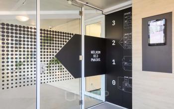 Ingang van het kantoorpand op Prins Willem-Alexanderlaan 301, Apeldoorn met glazen deur en moderne decoraties, perfect voor kantoorruimte huren.