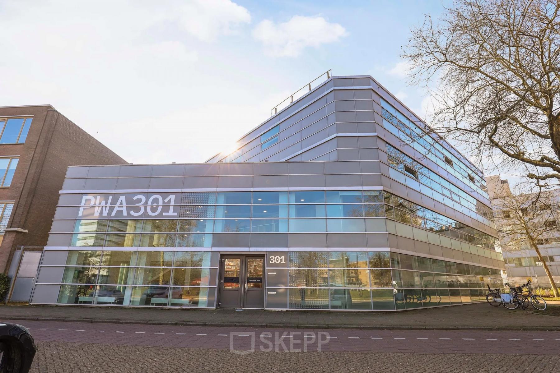 Modern kantoorpand op Prins Willem-Alexanderlaan 301 in Apeldoorn, met glazen gevel en ruime parkeerplaats vooraan. Ideaal als representatieve kantoorruimte voor bedrijven die willen huren.