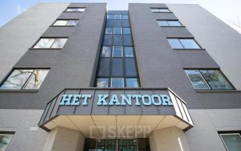 De voorzijde van een kantoorpand aan de Prins Willem-Alexanderlaan 401 in Apeldoorn, met een modern design en grote ramen.