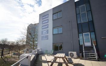Kantoorpand aan de Prins Willem-Alexanderlaan 401 in Apeldoorn met terras en picknicktafels.
