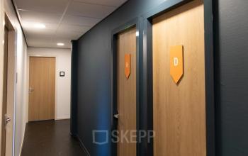 Gang in kantoorpand op Prins Willem-Alexanderlaan 401, Apeldoorn, met gesloten deuren en strakke afwerking.