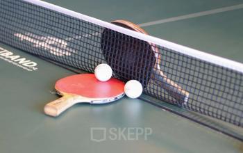 Tafeltennistafel met twee rackets en ballen in een kantoorpand aan Prins Willem-Alexanderlaan 401 in Apeldoorn voor ontspanning tijdens het werk.