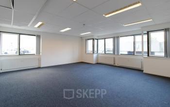 Leeg kantoorpand op Prins Willem-Alexanderlaan 401 in Apeldoorn, met ruime ramen en blauwe vloerbedekking, geschikt voor kantoorruimte huren.