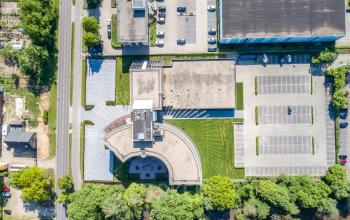 Luchtfoto van kantoorpand Landdrostlaan 51 in Apeldoorn met parkeerplaatsen en groene omgeving voor kantoorruimte huren.