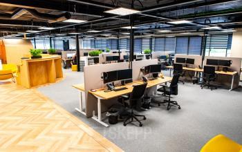 Kantoorruimte huren op Landdrostlaan 51 in Apeldoorn met moderne inrichting, inclusief werkplekken met bureaus, stoelen en computers in een ruime open vloerindeling.