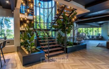 Moderne kantoorruimte op Landdrostlaan 51, Apeldoorn met een stijlvolle trap en veel natuurlijk lichtinval, omringd door planten en moderne inrichting, ideaal voor kantoorruimte huren.