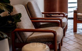 Gezellige zithoek in gemeubileerd kantoorpand aan de Lange Amerikaweg 55-61 in Apeldoorn, met comfortabele stoelen en planten.