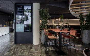 Moderne gemeubileerde kantoorpand met zitgedeelte en planten, gelegen aan de Lange Amerikaweg 55-61 in Apeldoorn.