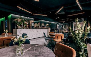 Stijlvolle kantoorruimte aan de Lange Amerikaweg 55-61 in Apeldoorn, met elegante meubels en een moderne bar, ideaal om te huren voor zakelijke bijeenkomsten.