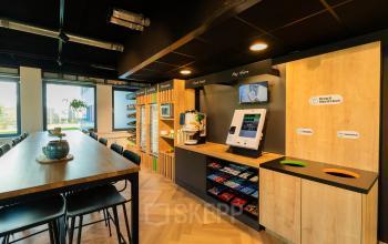 Moderne kantoorpand op Prins Willem Alexanderlaan 701, Apeldoorn, met een goed uitgeruste pantry en een lange tafel voor werk of bijeenkomsten, ideaal voor kantoorruimte huren.